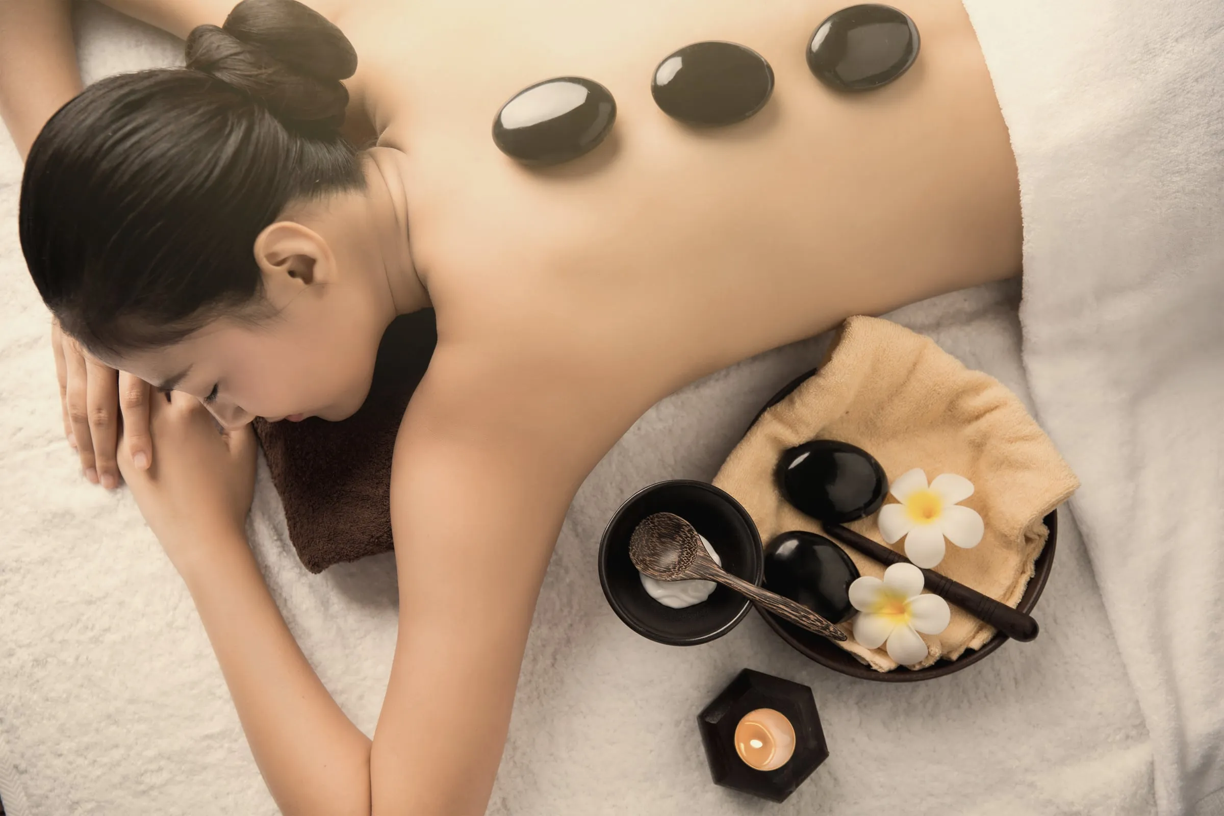 Warm basalt stones placed along a client’s back during a spa ritual