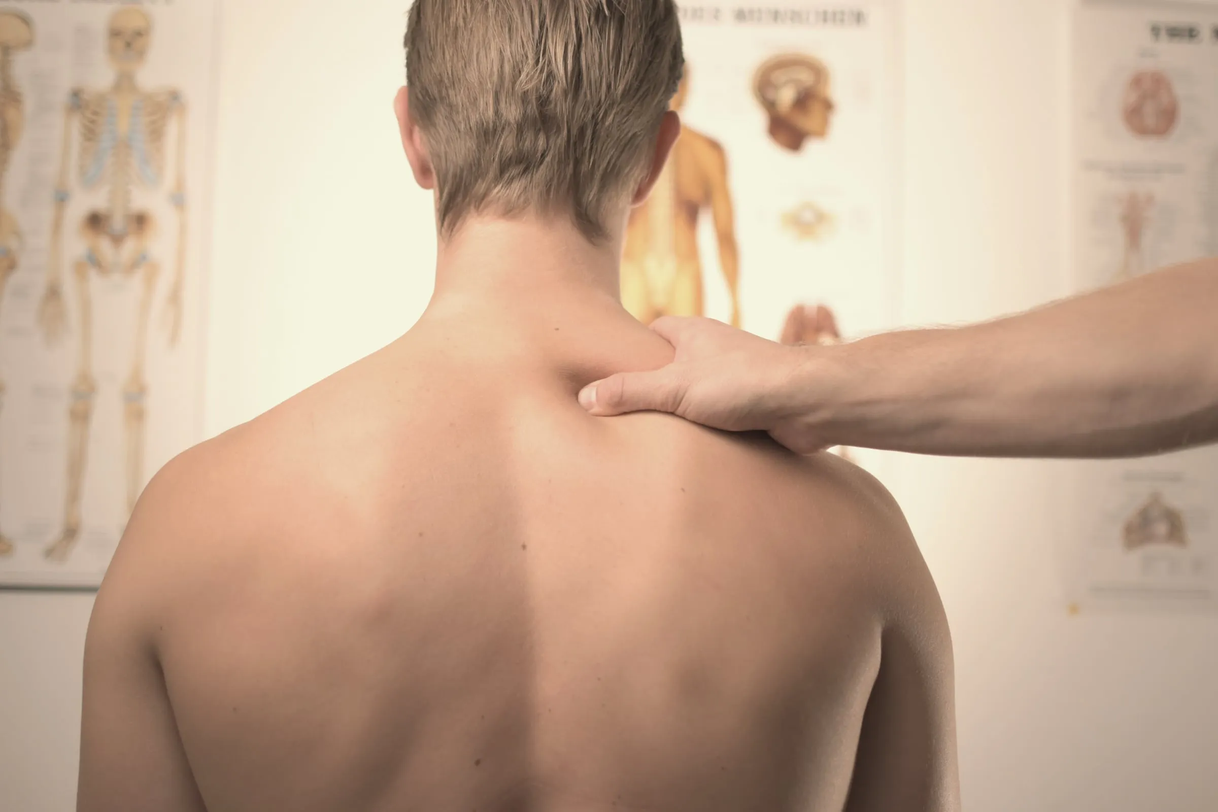 Therapist assessing a client’s shoulder before a sports massage in Freeport, FL